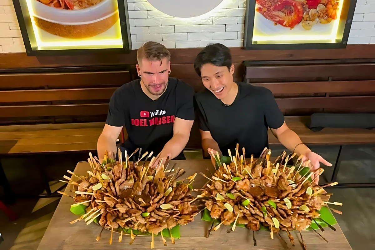 Two challengers at a table of moo ping skewers
